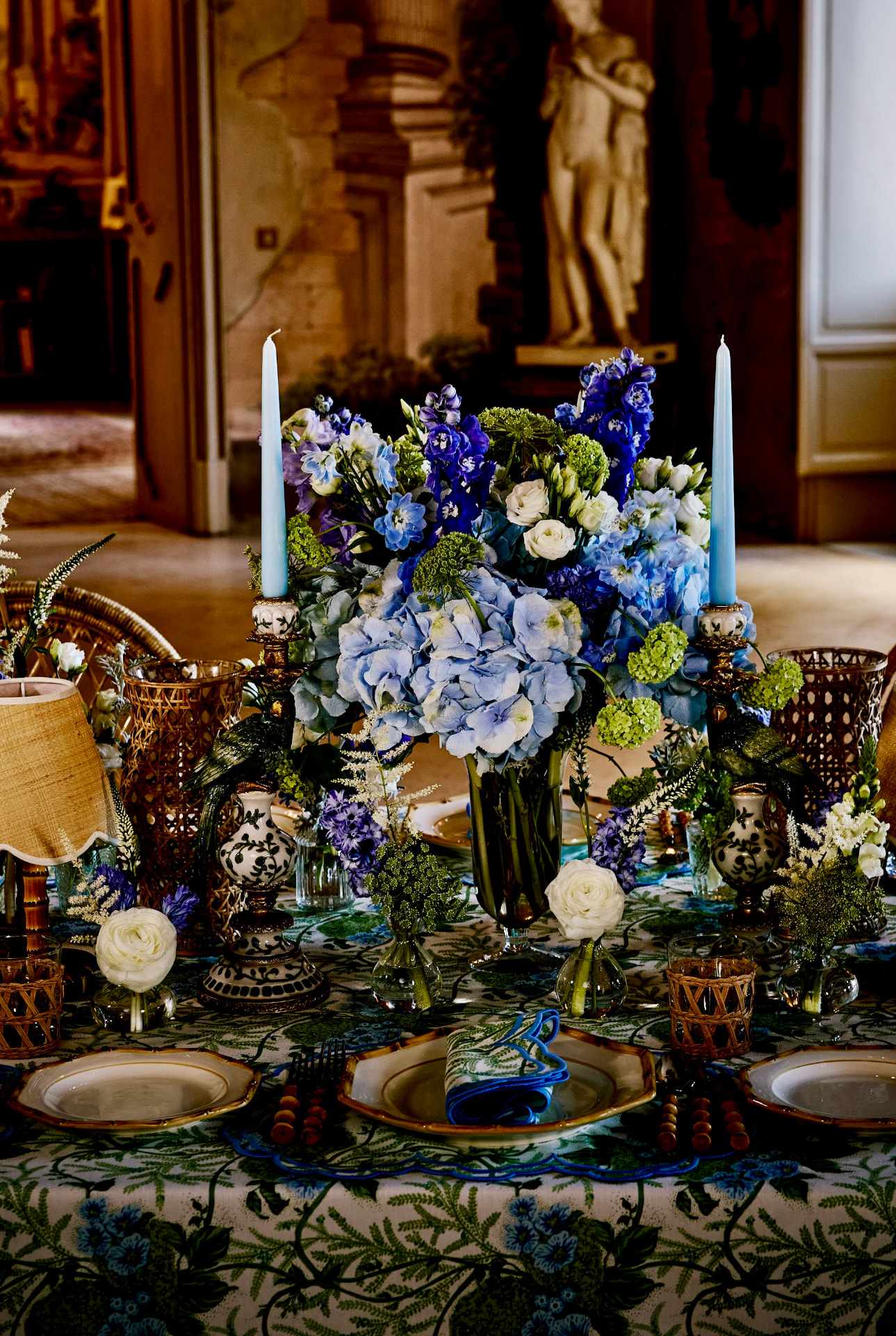 Summer table laid with blue flowers and patterned tableware